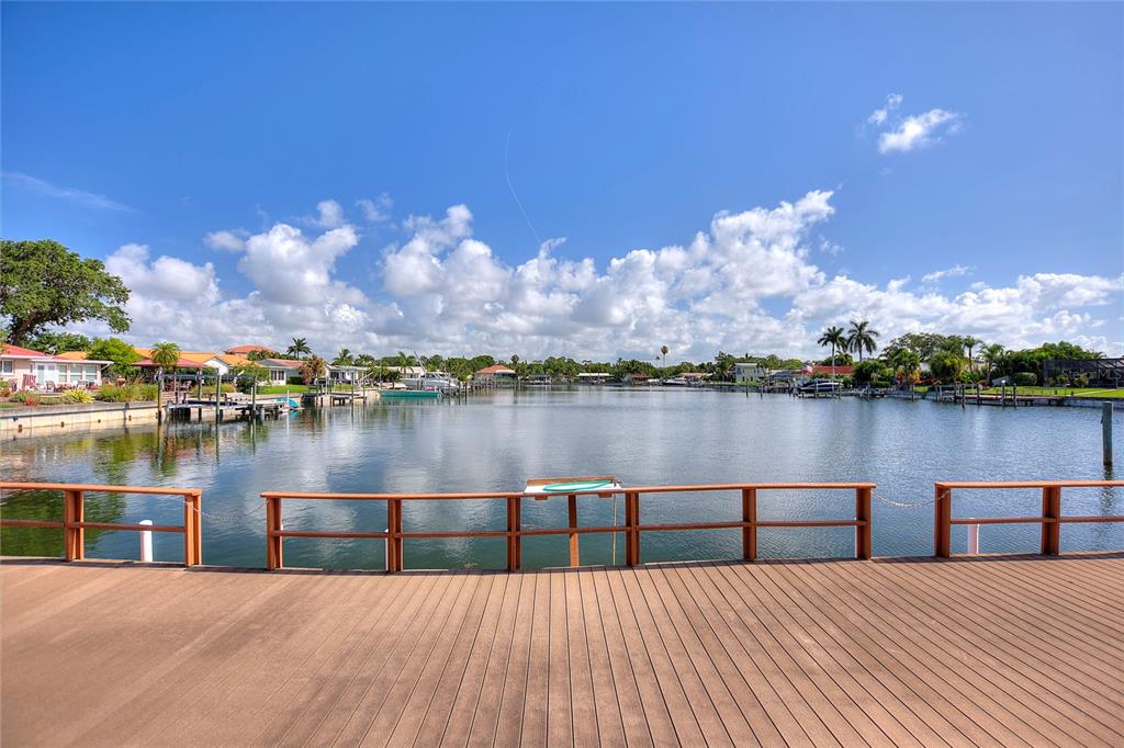 A wooden deck with a railing overlooks a calm canal lined with houses and docks — 3753 46TH AVENUE S UNIT 10, ST PETERSBURG, FL