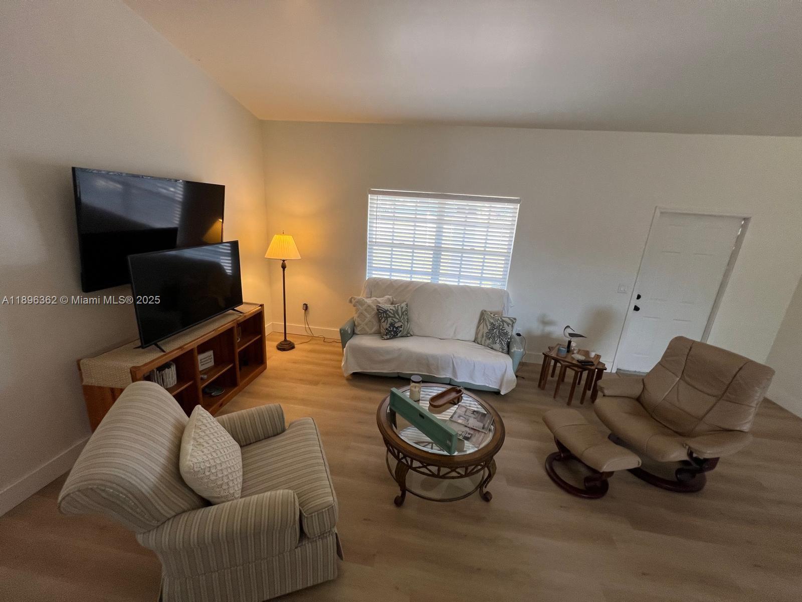 A living room features light wood flooring, a sofa, two armchairs, and a television console — 6191 Drucker circle, Port Charlotte FL 33981, PORT CHARLOTTE, FL