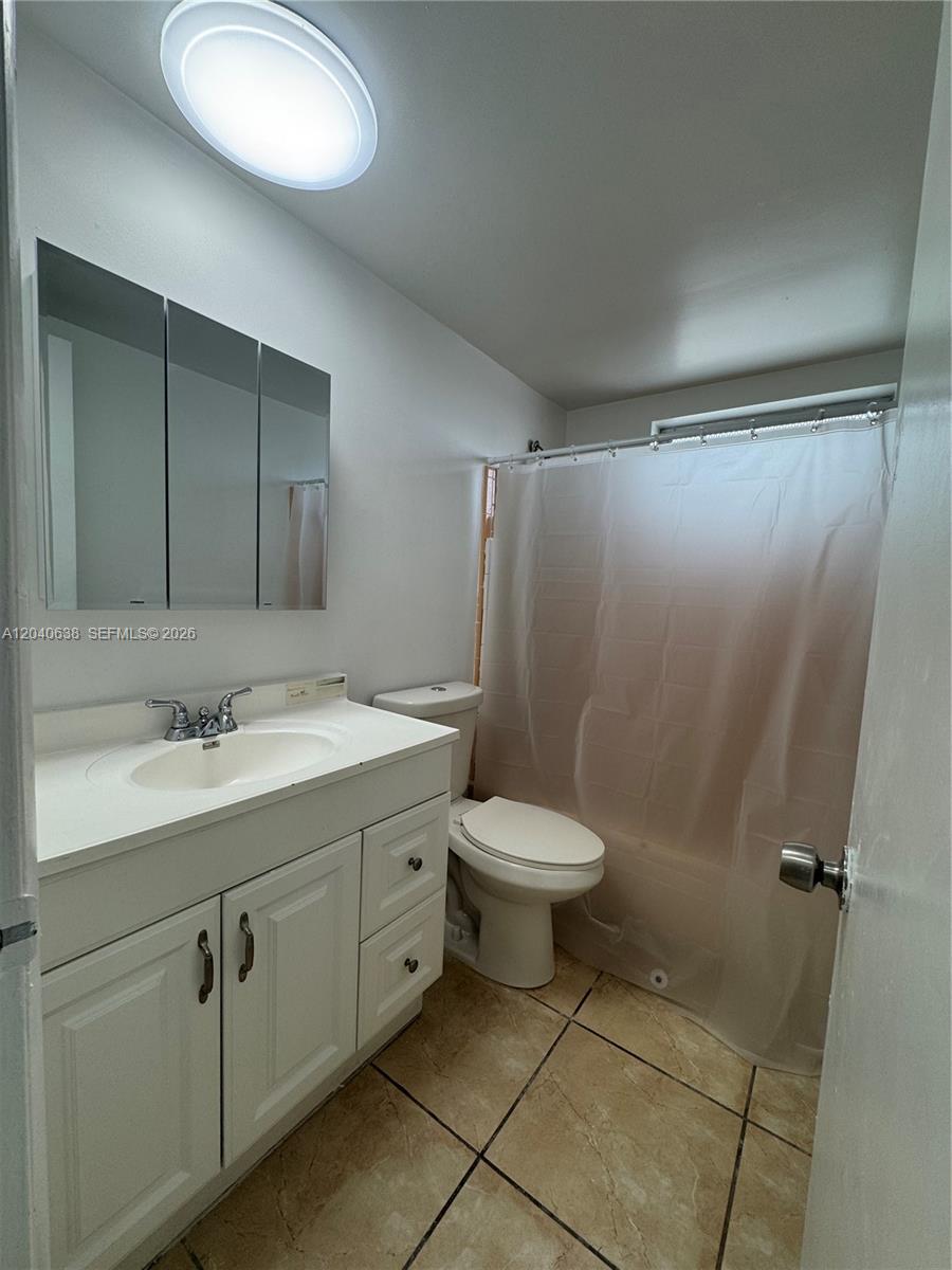 A bathroom features a white vanity, a medicine cabinet, a toilet, and a shower curtain — 1600 NE 114th St # 204, Miami FL 33181, MIAMI, FL