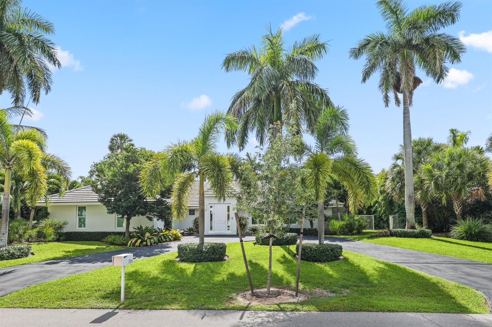 A single-story house with a white exterior, a circular driveway, and numerous palm trees — 1386 S Atlantic Drive, Lantana FL 33462, LANTANA, FL
