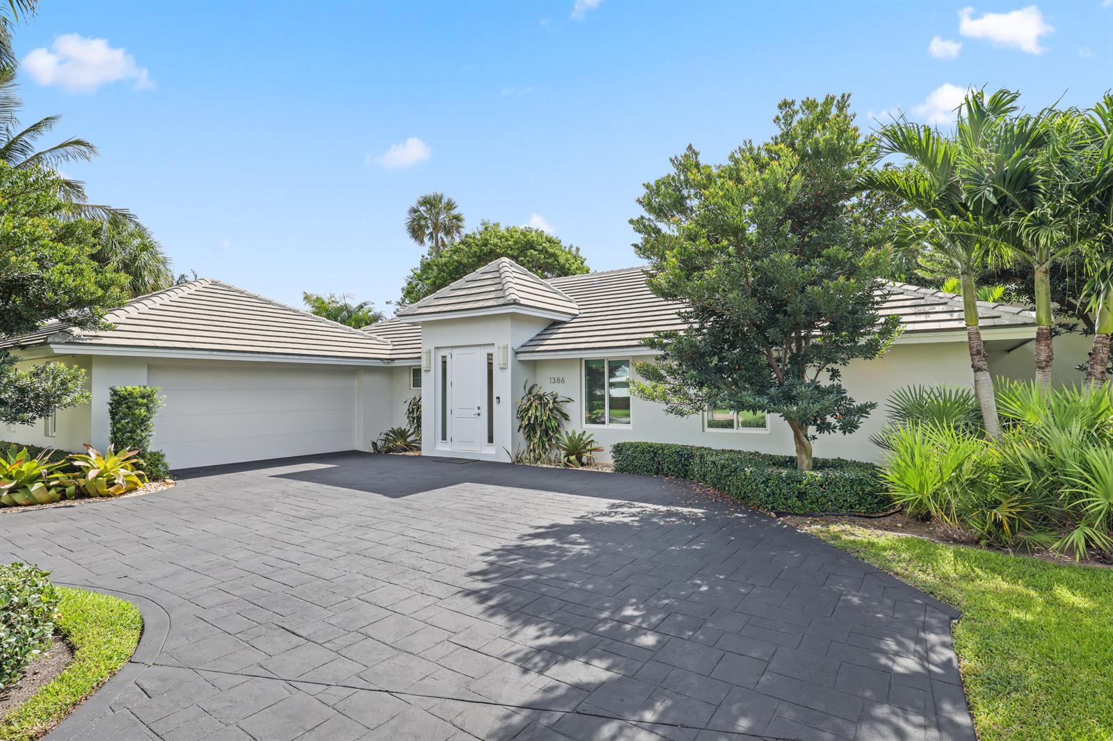 A single-story house with a white exterior, tiled roof, and a dark paved circular driveway — 1386 S Atlantic Drive, Lantana FL 33462, LANTANA, FL
