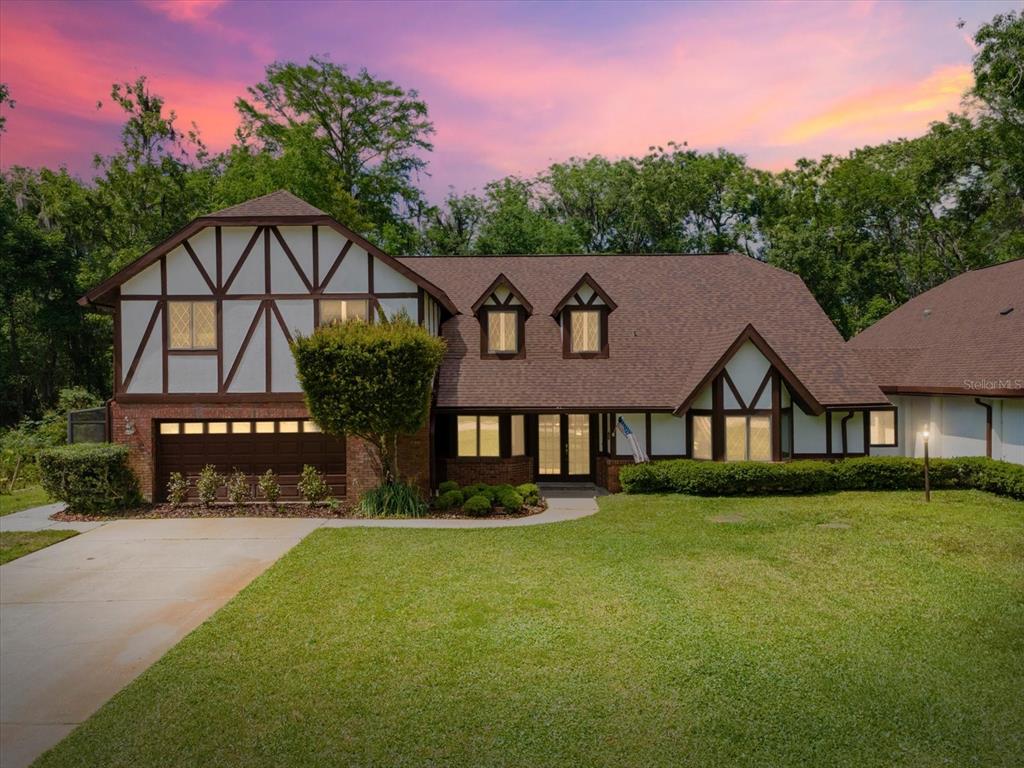 A two-story Tudor-style house with a brown shingled roof and a front-facing garage — 10721 SKYHAWK DRIVE, NEW PORT RICHEY, FL