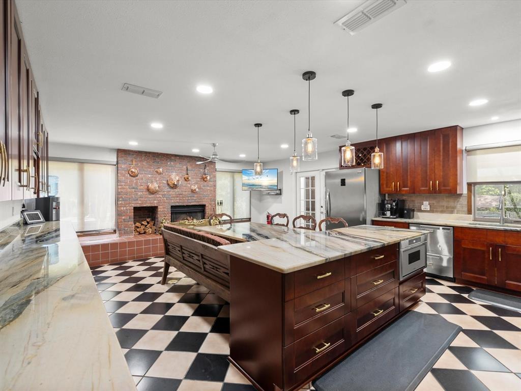 A kitchen features a large marble island, dark wood cabinetry, and a black-and-white checkered floor — 10721 SKYHAWK DRIVE, NEW PORT RICHEY, FL