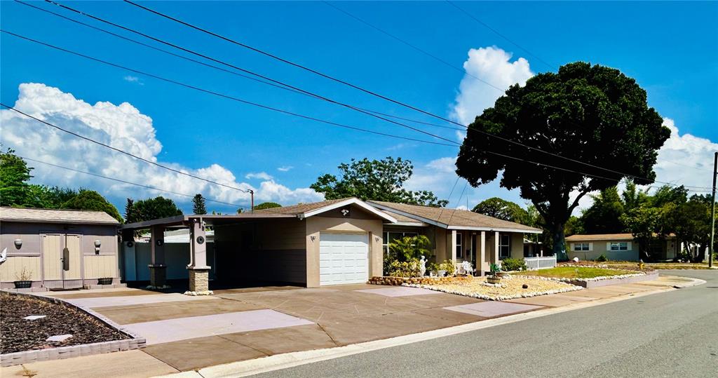 A single-story house with a carport and a large tree stands beside a street — 6190 6TH STREET S, ST PETERSBURG, FL
