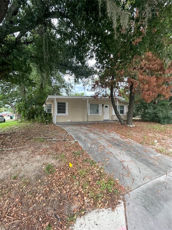 A single-story house with light-colored siding and a concrete driveway sits under large trees — 4615 CLARCONA OCOEE ROAD, ORLANDO, FL