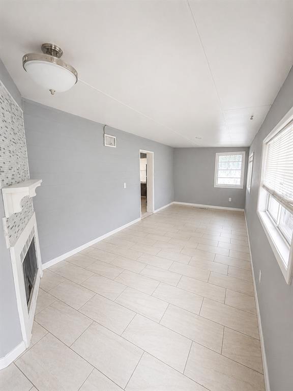 A room with light gray walls, tile flooring, a fireplace, and a ceiling light fixture — 4615 CLARCONA OCOEE ROAD, ORLANDO, FL