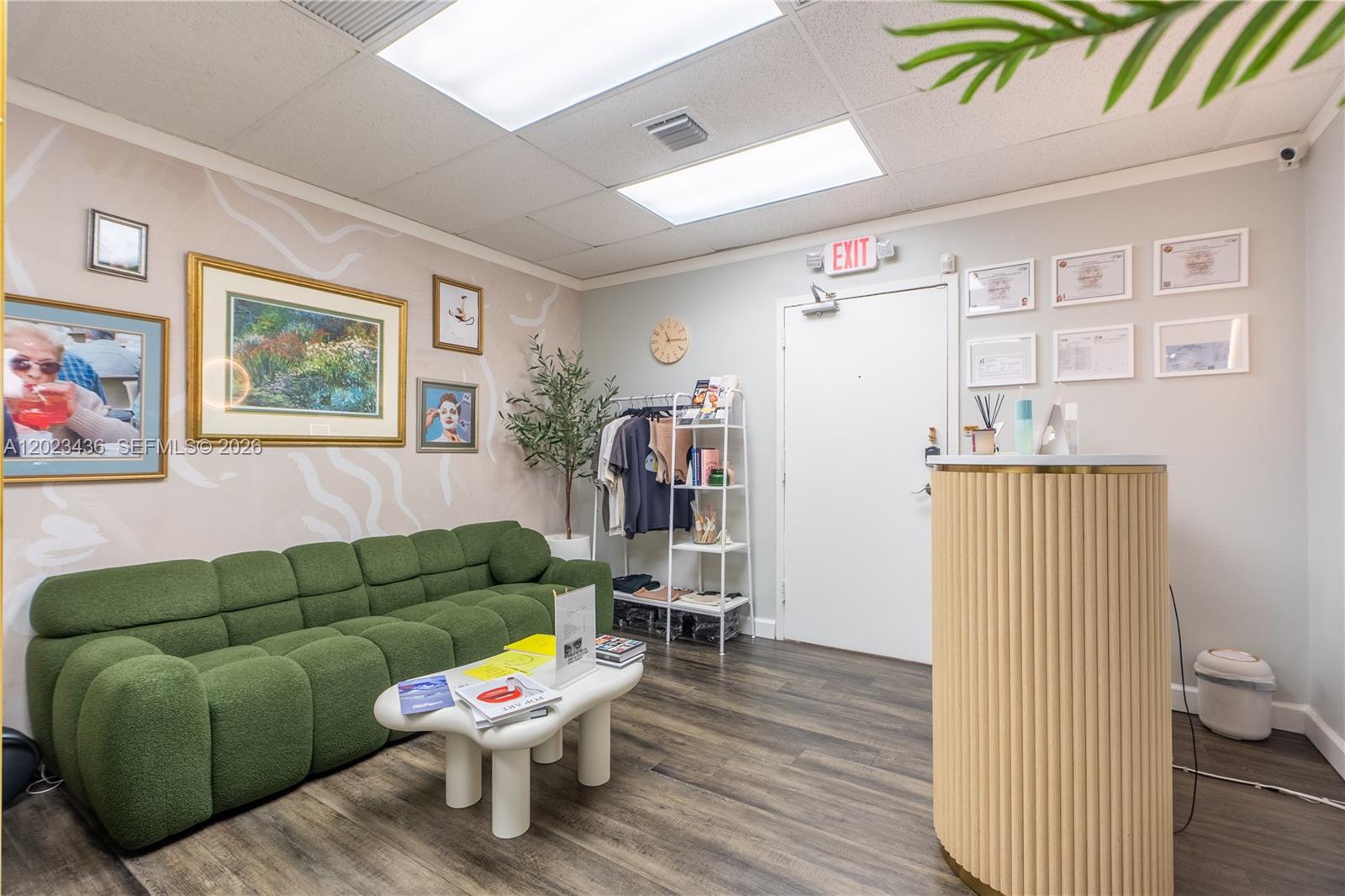 A waiting room features a green sofa, a white coffee table, and a reception desk — 1250 E Hallandale Beach Blvd, Hallandale Beach FL 33009, HALLANDALE BEACH, FL