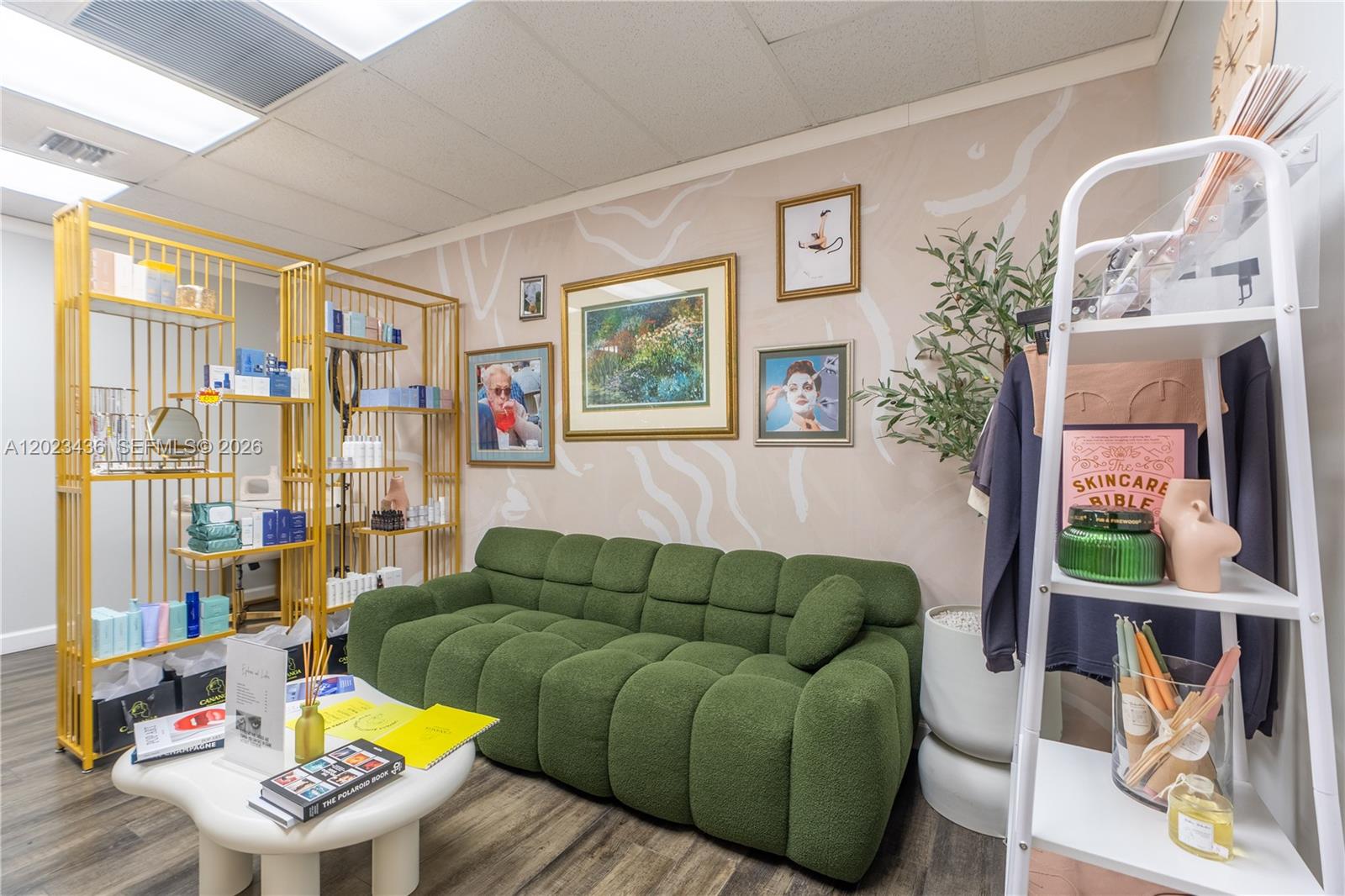 A waiting area features a green tufted sofa, a gold shelving unit, and wall art — 1250 E Hallandale Beach Blvd, Hallandale Beach FL 33009, HALLANDALE BEACH, FL
