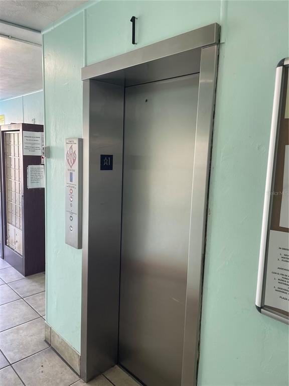A stainless steel elevator door is located in a hallway with light green walls — 223 COLUMBIA DRIVE UNIT 211, CAPE CANAVERAL, FL