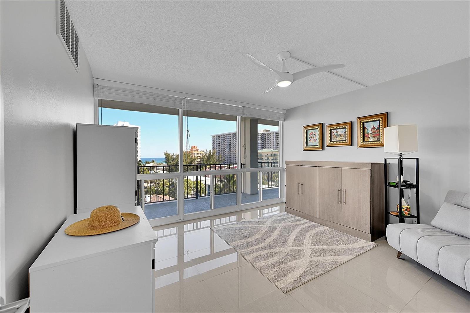 A bright room features a murphy bed, a sofa, tile flooring, and a balcony with ocean views — 521 N Riverside Drive # 707, Pompano Beach FL 33062, POMPANO BEACH, FL