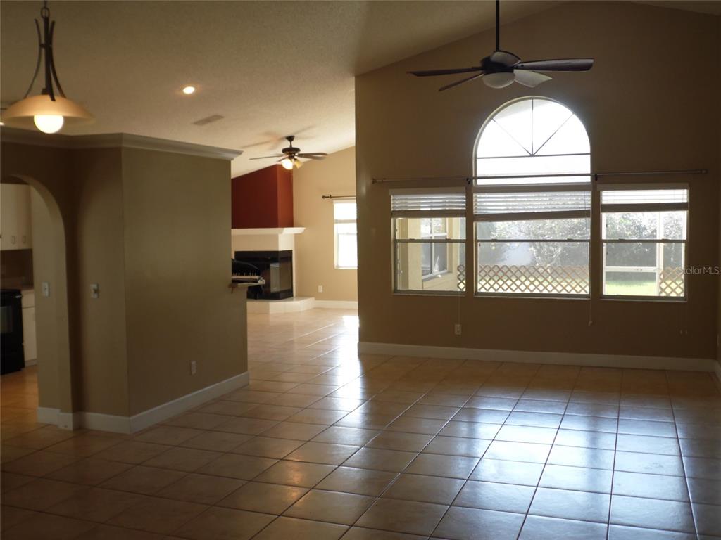 An open living area features tile flooring, a vaulted ceiling, and a fireplace — 11020 FELTON COURT, ORLANDO, FL