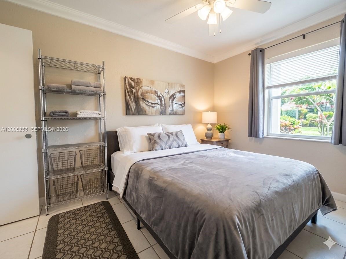 A bedroom features a bed with grey bedding, a metal shelving unit, and a window — 8605 SW 68th Ct # 7, Pinecrest FL 33156, PINECREST, FL