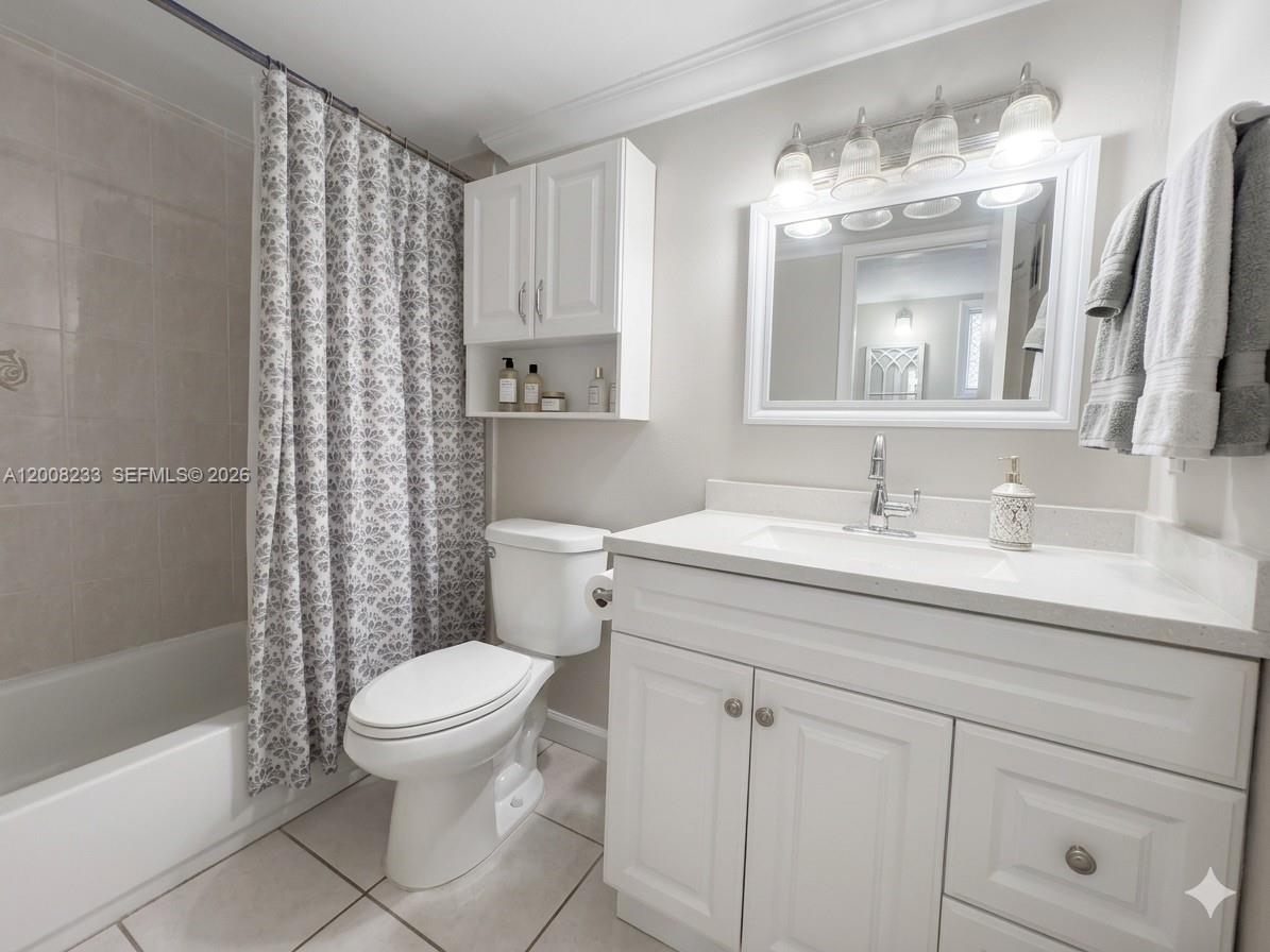 A bathroom features a white vanity, a toilet, a shower-tub combo, and a wall cabinet — 8605 SW 68th Ct # 7, Pinecrest FL 33156, PINECREST, FL