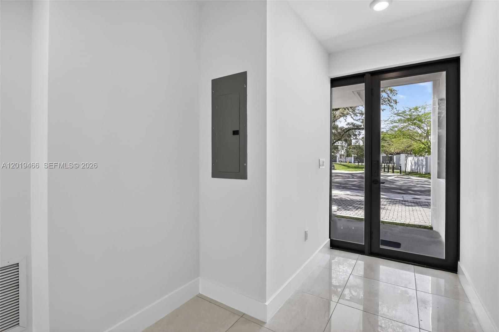 A bright entryway features a gray electrical panel on a white wall and a glass door — 4101 N Oak Pl, Dania Beach FL 33314, DANIA BEACH, FL