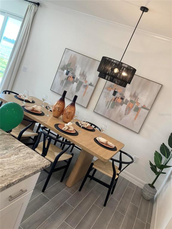 A dining room features a wooden table, black chairs, two abstract paintings, and a pendant light — 25584 CALUSA DRIVE, PUNTA GORDA, FL