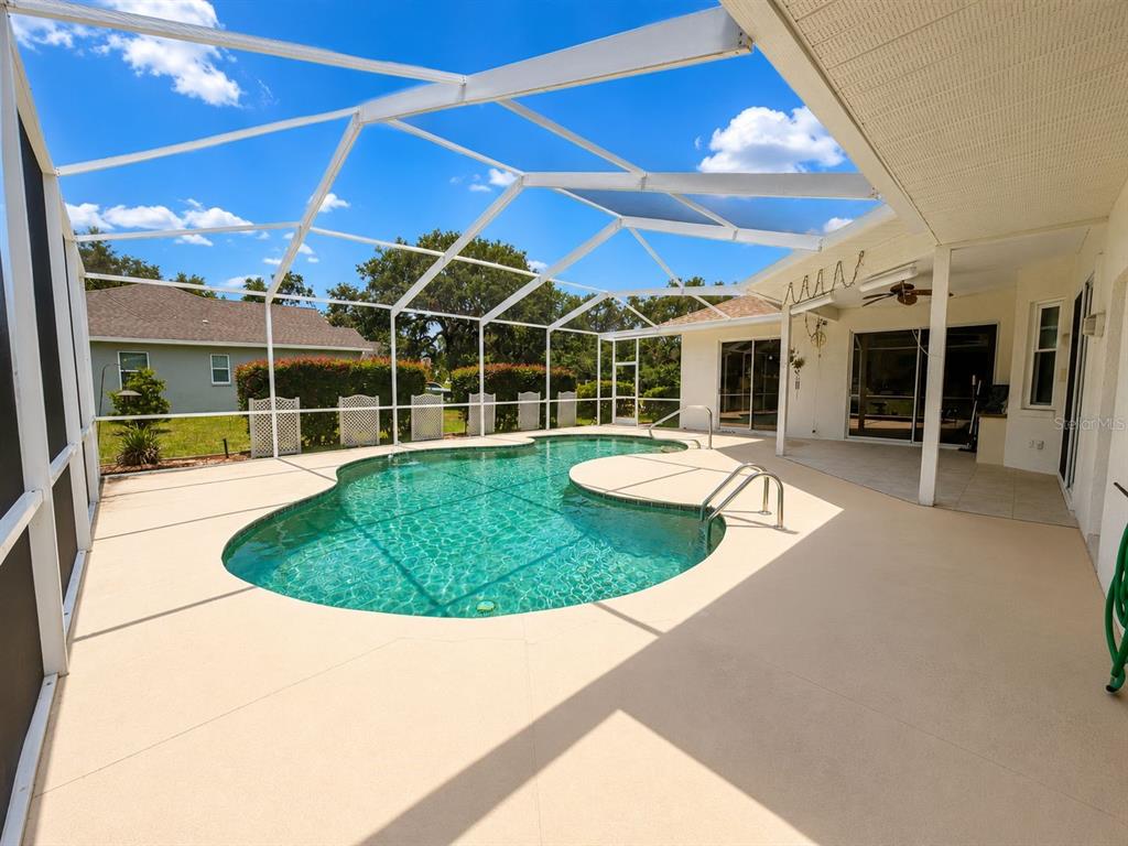 A screened-in patio features a swimming pool with a sun shelf and a covered lanai — 48 N CRYSTAL MEADOW PATH, LECANTO, FL