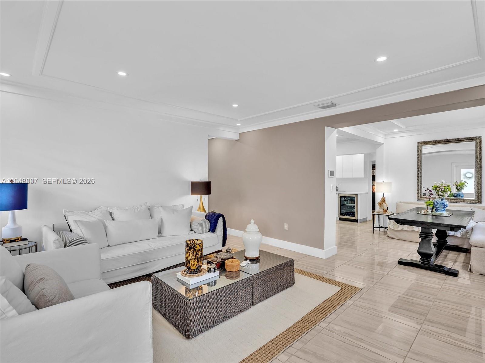 A living room with white sofas, a wicker coffee table, and an adjacent dining area — 310 SW 65th Ave, Miami FL 33144, MIAMI, FL