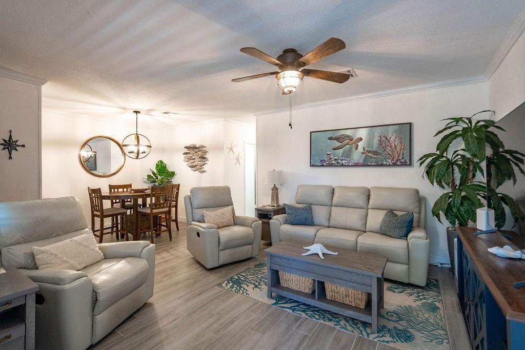 A living room and dining area with light gray tile floors, leather furniture, and coastal decor — 2100 NE 38th Street # 229, Lighthouse Point FL 33064, LIGHTHOUSE POINT, FL