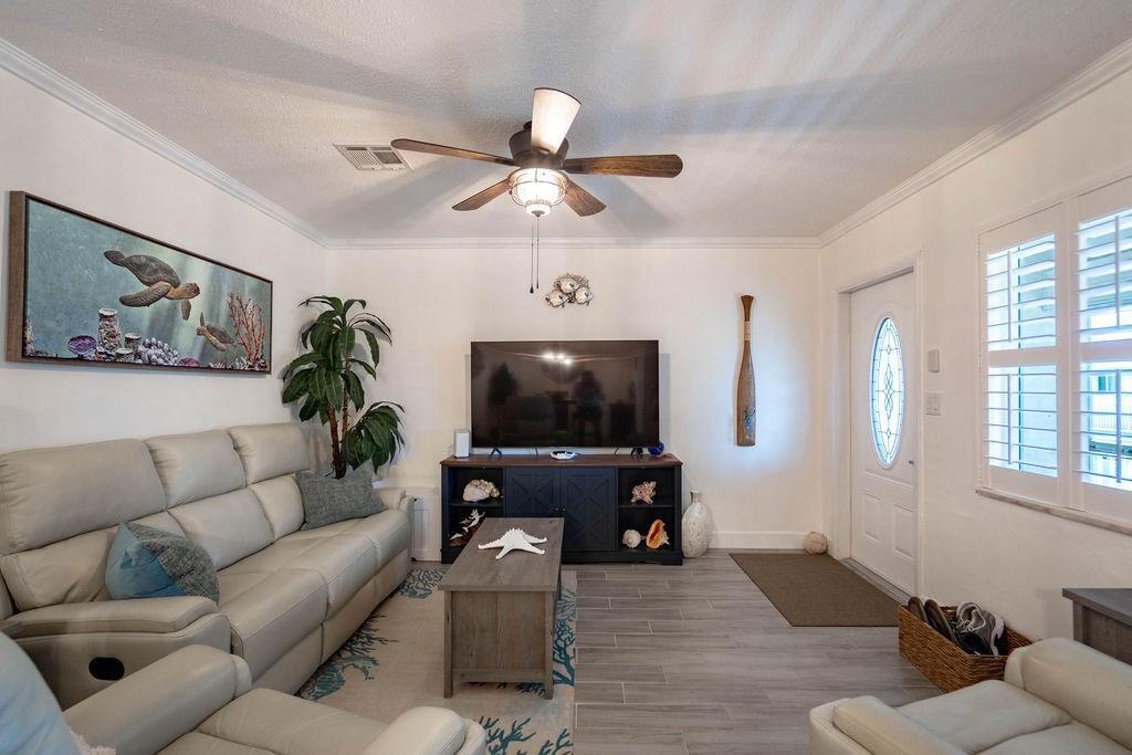 A living room features a light-colored sofa, a television on a dark console, and tile flooring — 2100 NE 38th Street # 229, Lighthouse Point FL 33064, LIGHTHOUSE POINT, FL