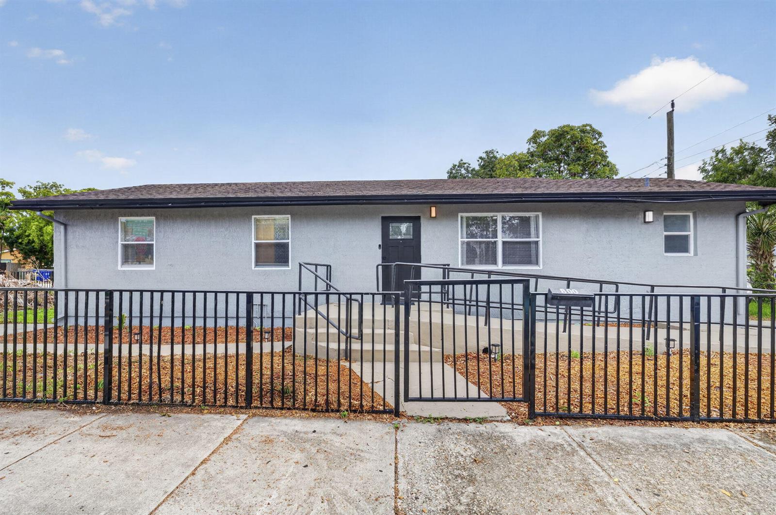 A single-story gray house features a black metal fence, a ramp, and a front door — 800 NW 6th Avenue, Pompano Beach FL 33060, POMPANO BEACH, FL