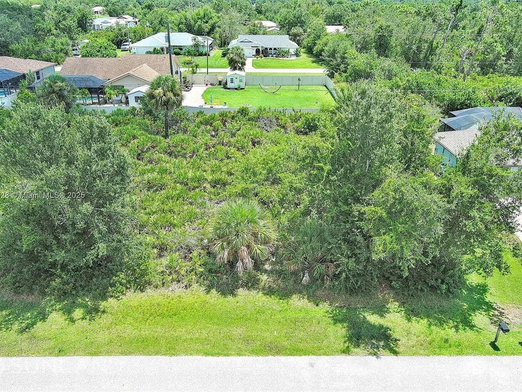 An aerial view shows a vacant, wooded residential lot situated between two existing houses — 7296 SKYCREST STREET, ENGLEWOOD, FL