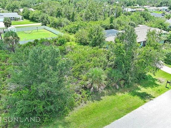 An aerial view shows a vacant, wooded residential lot situated between two existing houses — 7296 SKYCREST STREET, ENGLEWOOD, FL