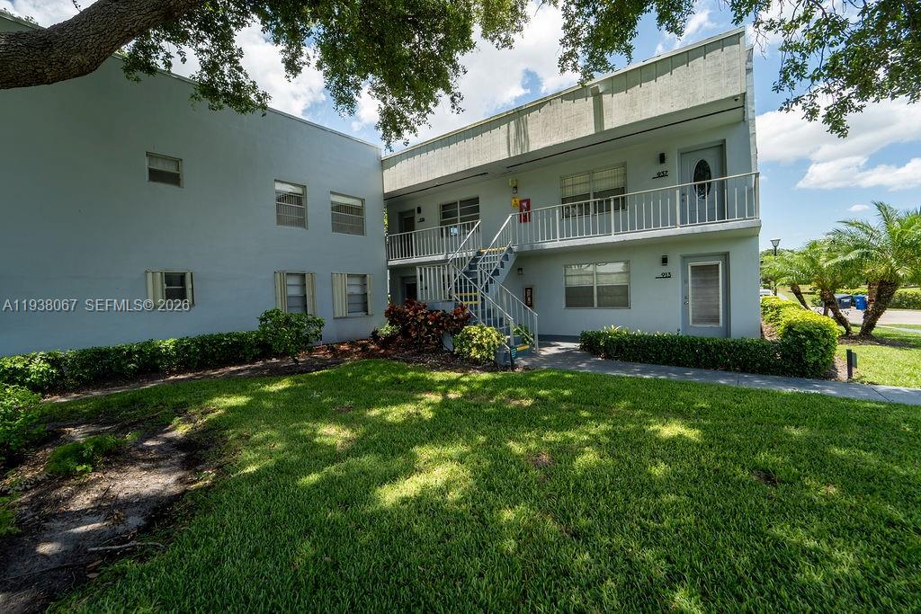 A two-story apartment building features a metal staircase leading to an upper-level balcony — 938 Normandy T # T938, Delray Beach FL 33484, DELRAY BEACH, FL