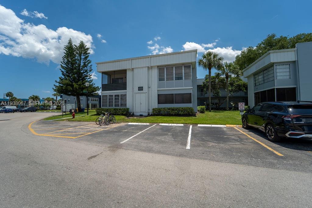 A two-story apartment building exterior with a parking lot in the foreground — 938 Normandy T # T938, Delray Beach FL 33484, DELRAY BEACH, FL