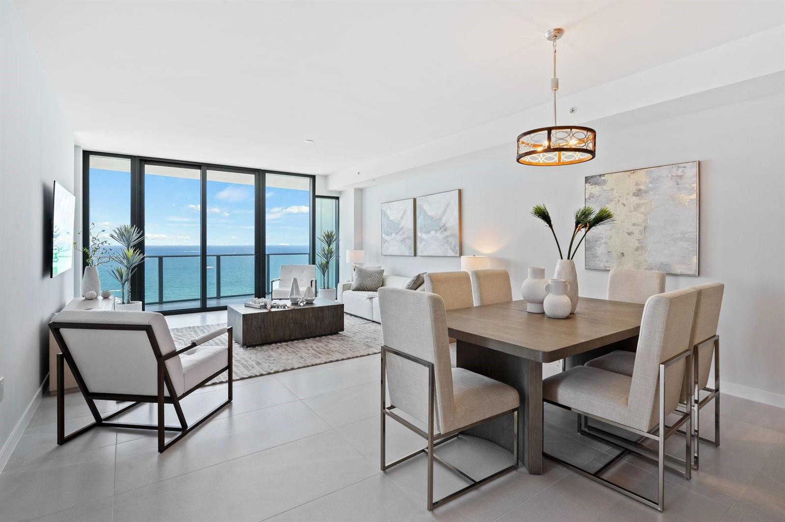 A modern open-concept living and dining area with floor-to-ceiling windows overlooking the ocean — 1116 N Ocean Boulevard # 1606, Pompano Beach FL 33062, POMPANO BEACH, FL