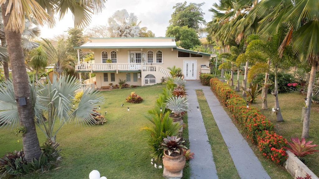 A two-story house with a balcony and a long driveway sits on a grassy lot — 393 MONTE CARMELO, VIEQUES, PR
