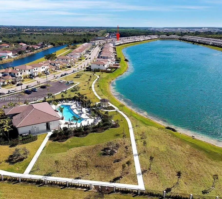 An aerial view shows a residential community with townhomes, a swimming pool, and a lake — 10162 SW 228th Ter, Miami FL 33190, MIAMI, FL