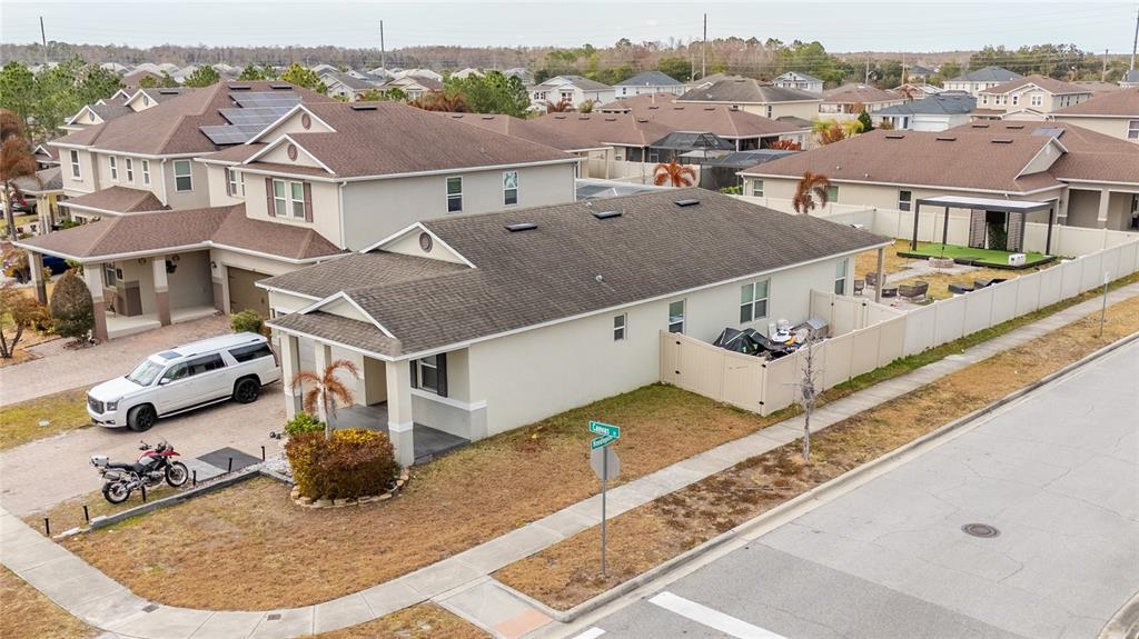 An aerial view shows a suburban house with a driveway, motorcycle, and fenced backyard — 3401 CANVAS STREET, KISSIMMEE, FL