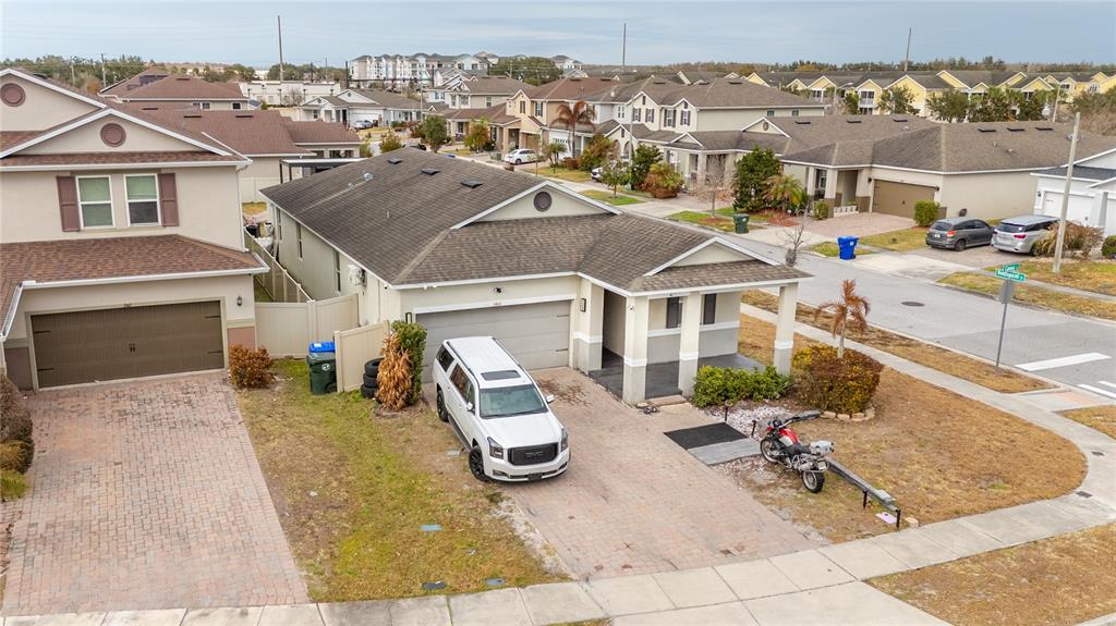 An aerial view of two suburban houses with paved driveways, a white SUV, and a motorcycle — 3401 CANVAS STREET, KISSIMMEE, FL