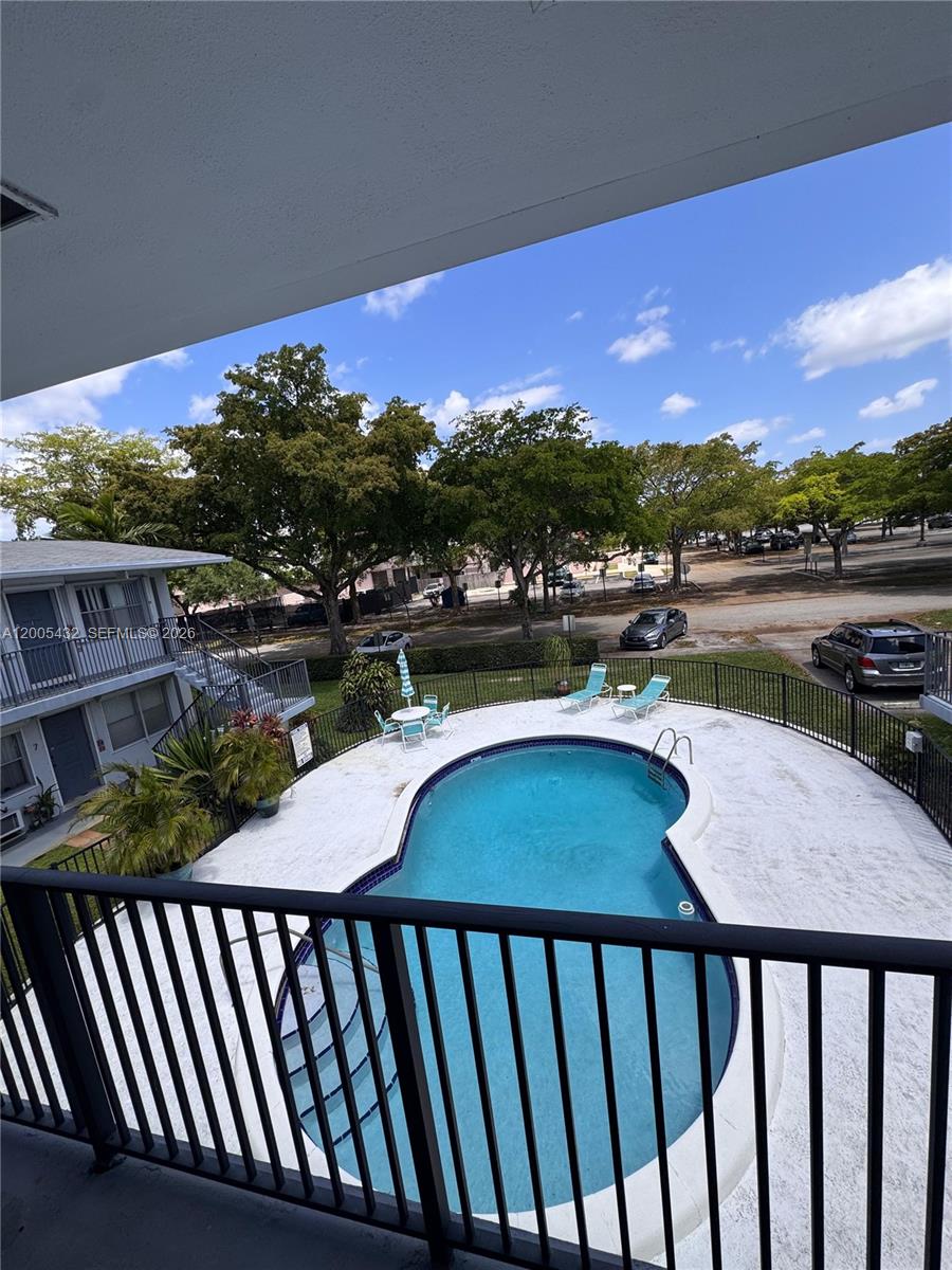 An elevated view of a swimming pool and parking lot from a balcony — 3510 Harrison St # 12, Hollywood FL 33021, HOLLYWOOD, FL