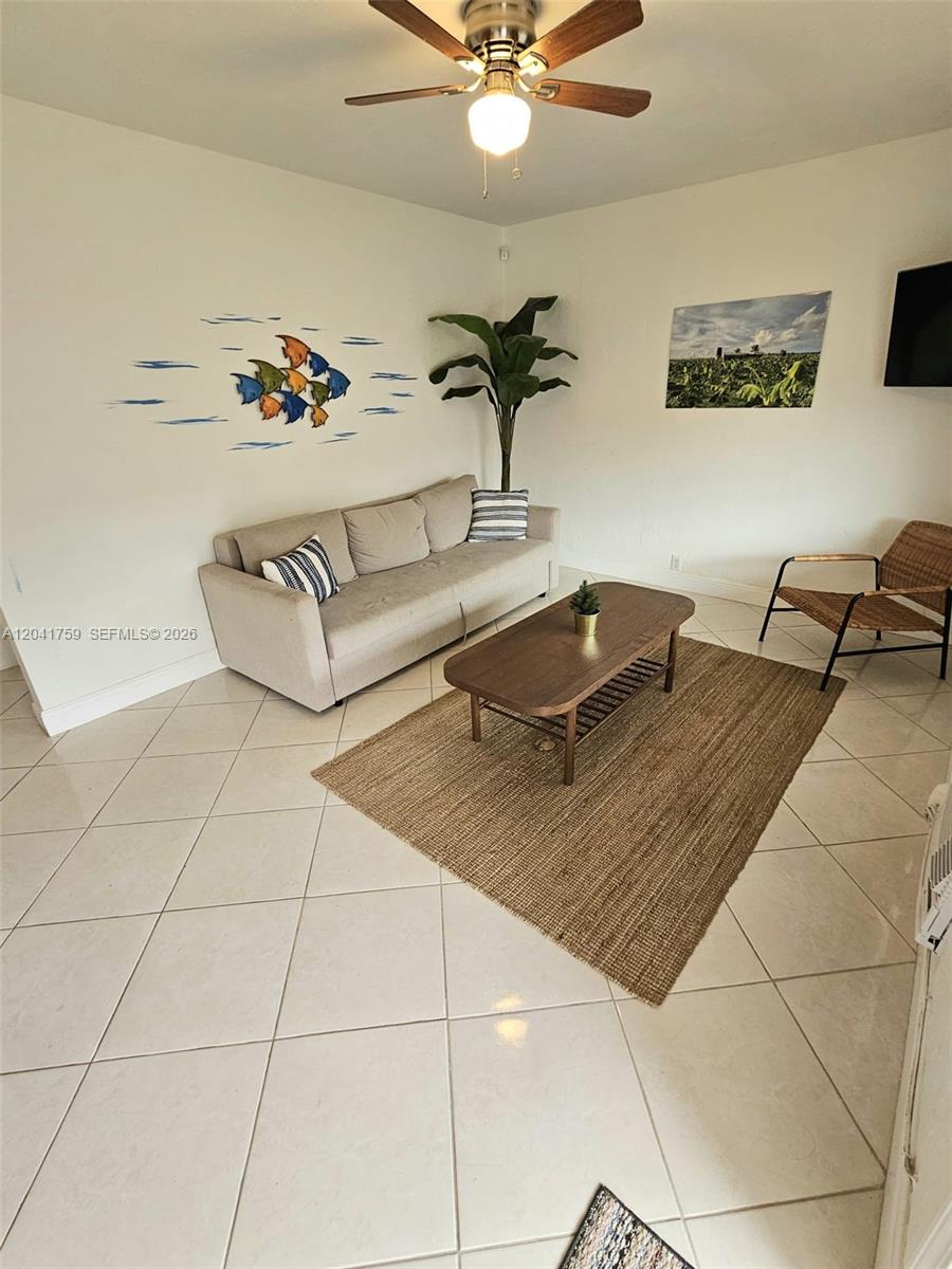 A living room features a beige sofa, a wooden coffee table, and a jute rug — 7400 Harding Ave # 22, Miami Beach FL 33141, MIAMI BEACH, FL