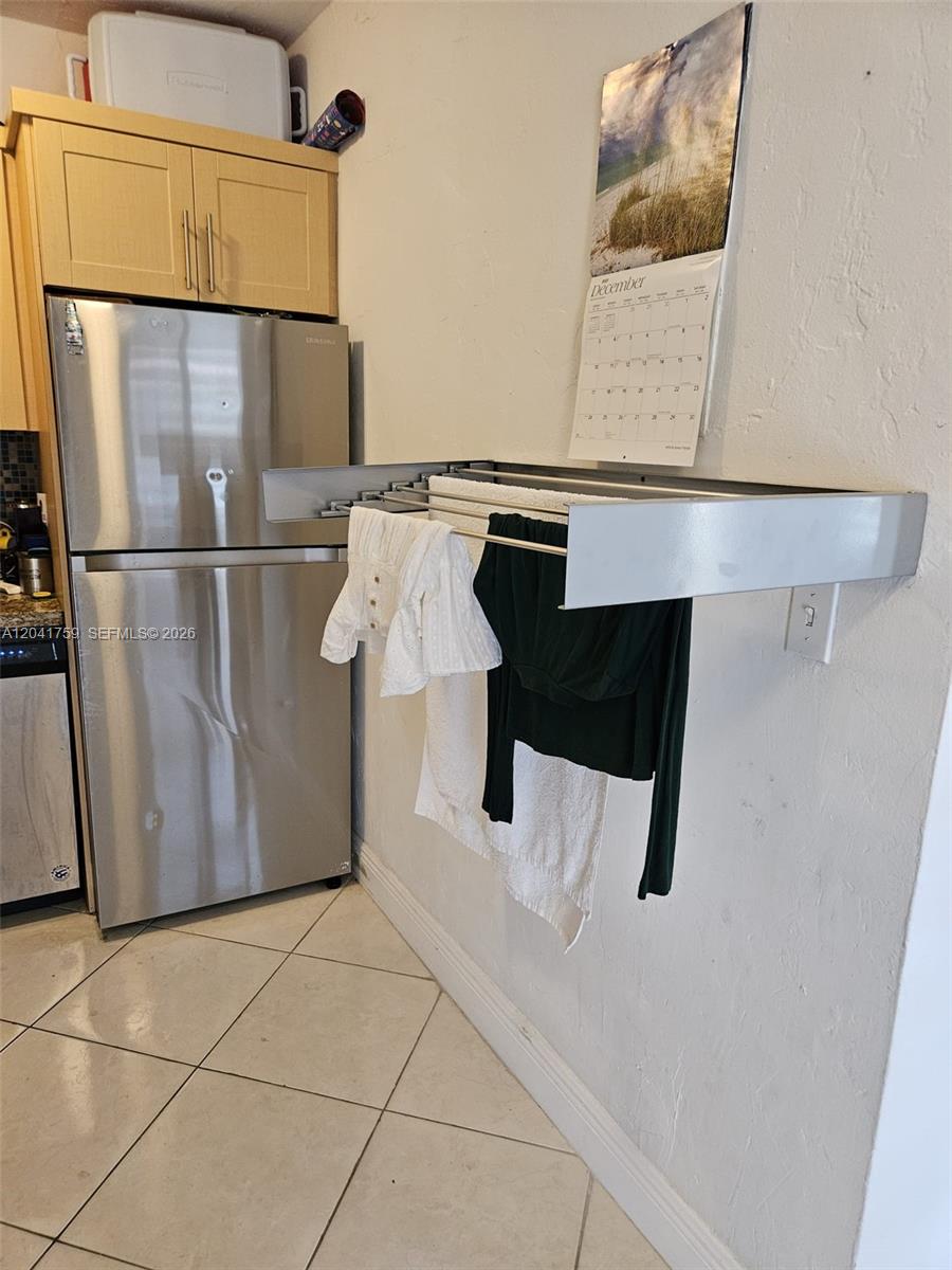 A kitchen features a stainless steel refrigerator and a wall-mounted retractable drying rack — 7400 Harding Ave # 22, Miami Beach FL 33141, MIAMI BEACH, FL