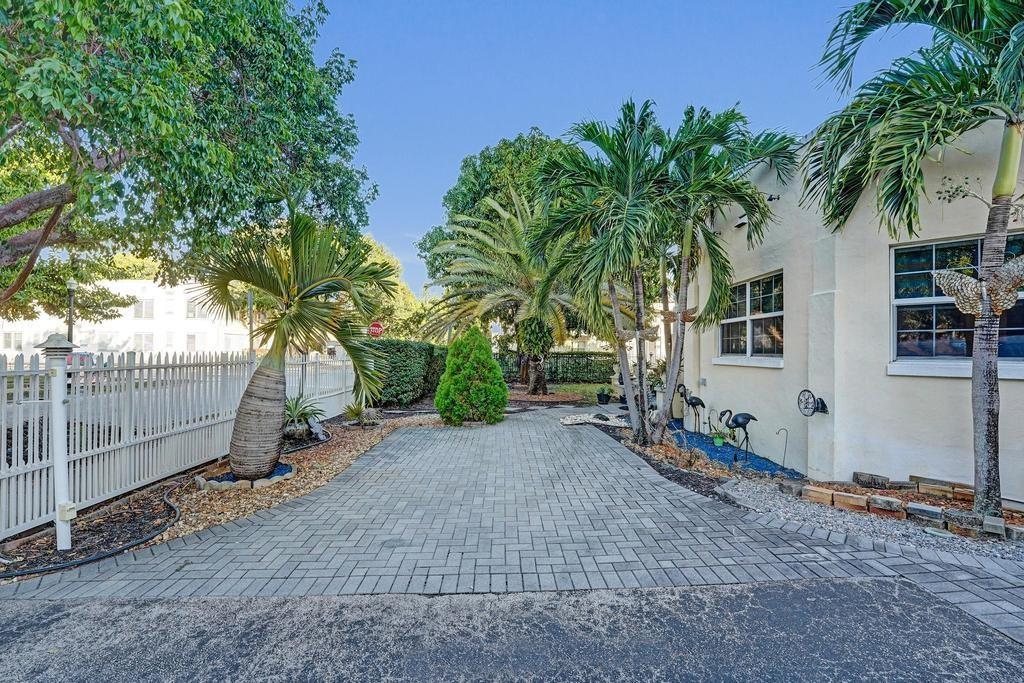 A paved driveway leads to the side of a building with palm trees and landscaping — 2000 Jackson Street, Hollywood FL 33020, HOLLYWOOD, FL