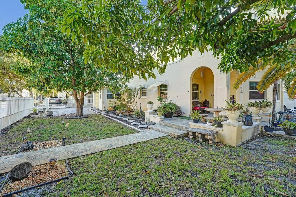 A single-story house with a stucco exterior, arched entryway, and a front yard with trees — 2000 Jackson Street, Hollywood FL 33020, HOLLYWOOD, FL