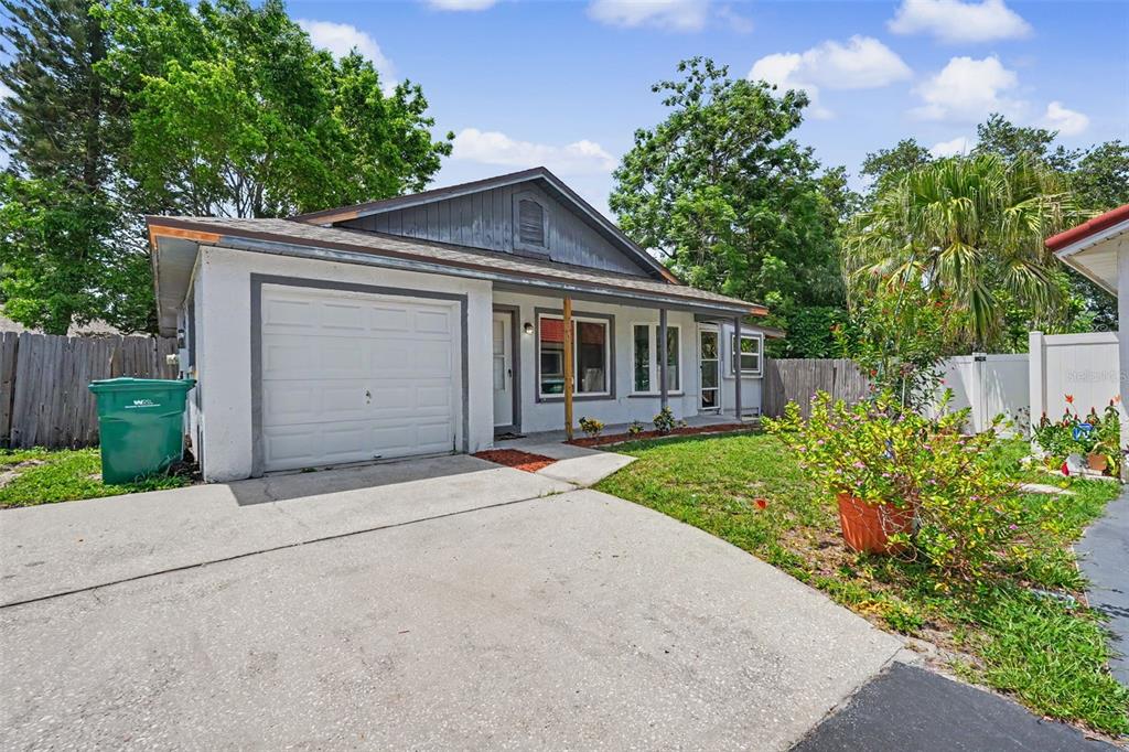 A single-story house with a white stucco exterior, a garage, and a front lawn — 3751 MACKENZIE COURT, PALM HARBOR, FL