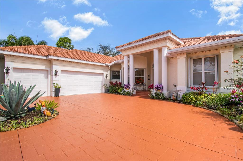 A dining room features a wooden table, wicker chairs, a chandelier, and a patterned rug — 7302 EATON COURT, UNIVERSITY PARK, FL