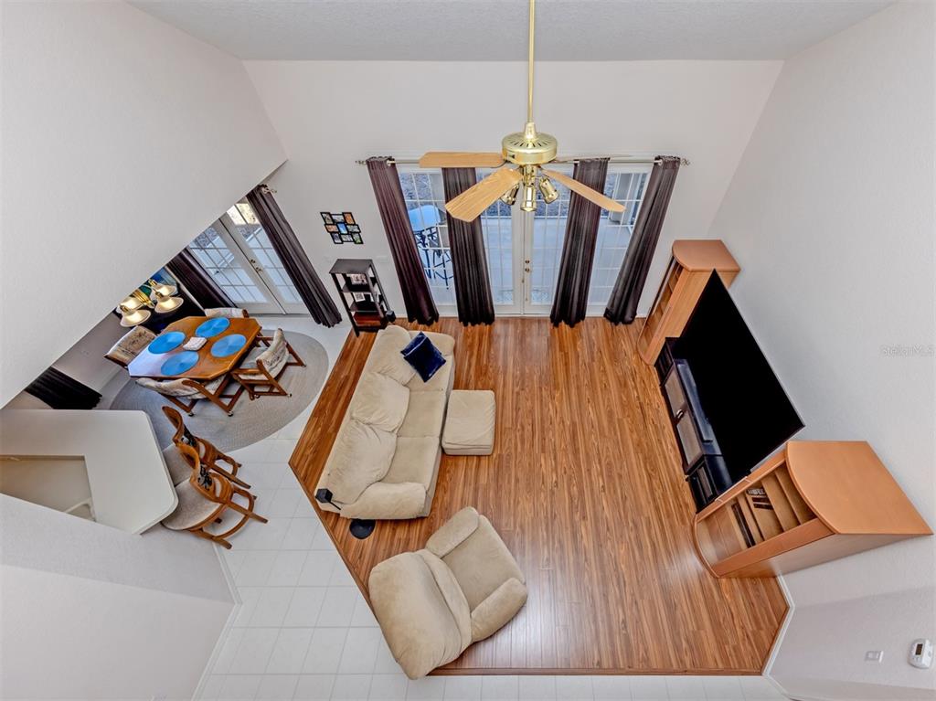 High-angle view of a living room and dining area with wood flooring and vaulted ceilings — 897 COLONIAL ROAD, VENICE, FL