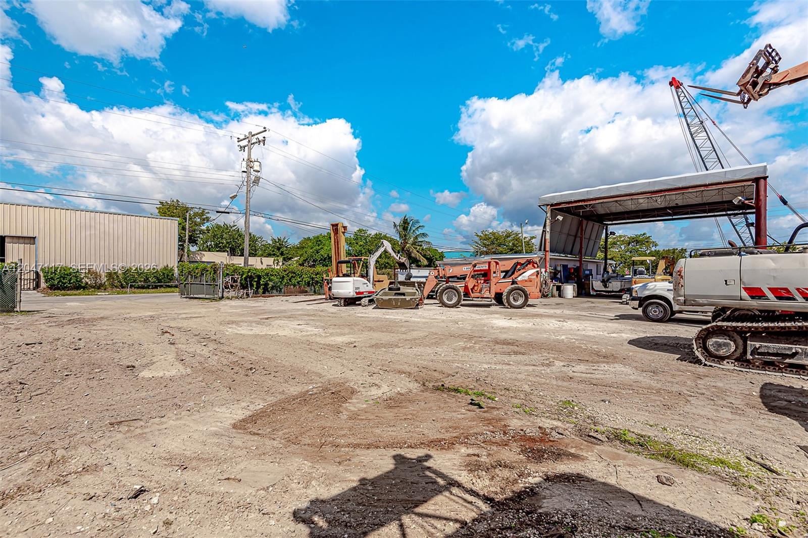 A dirt lot features heavy construction equipment, a covered work area, and a metal building — 2301 SW 57th Ave, West Park FL 33023, WEST PARK, FL