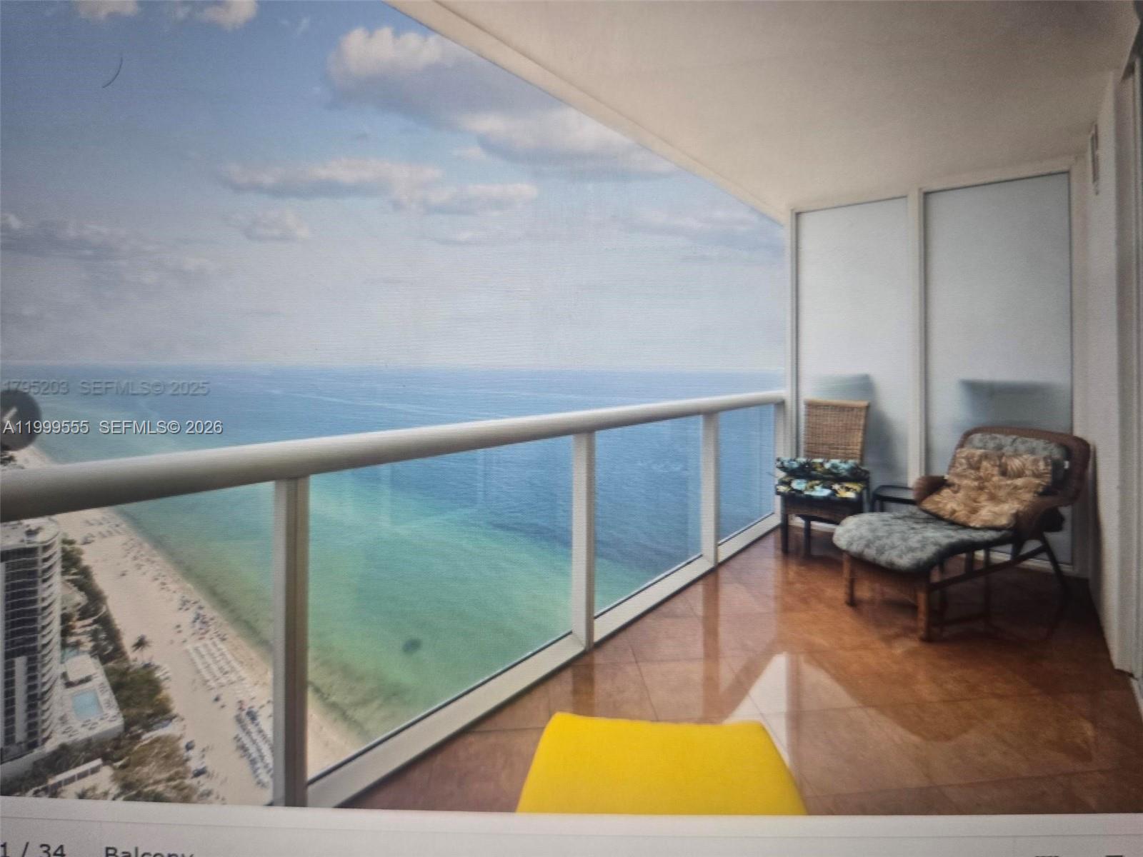 A balcony with tiled flooring, patio furniture, and a glass railing overlooking the ocean — 1830 S Ocean Dr # 4309, Hallandale Beach FL 33009, HALLANDALE BEACH, FL