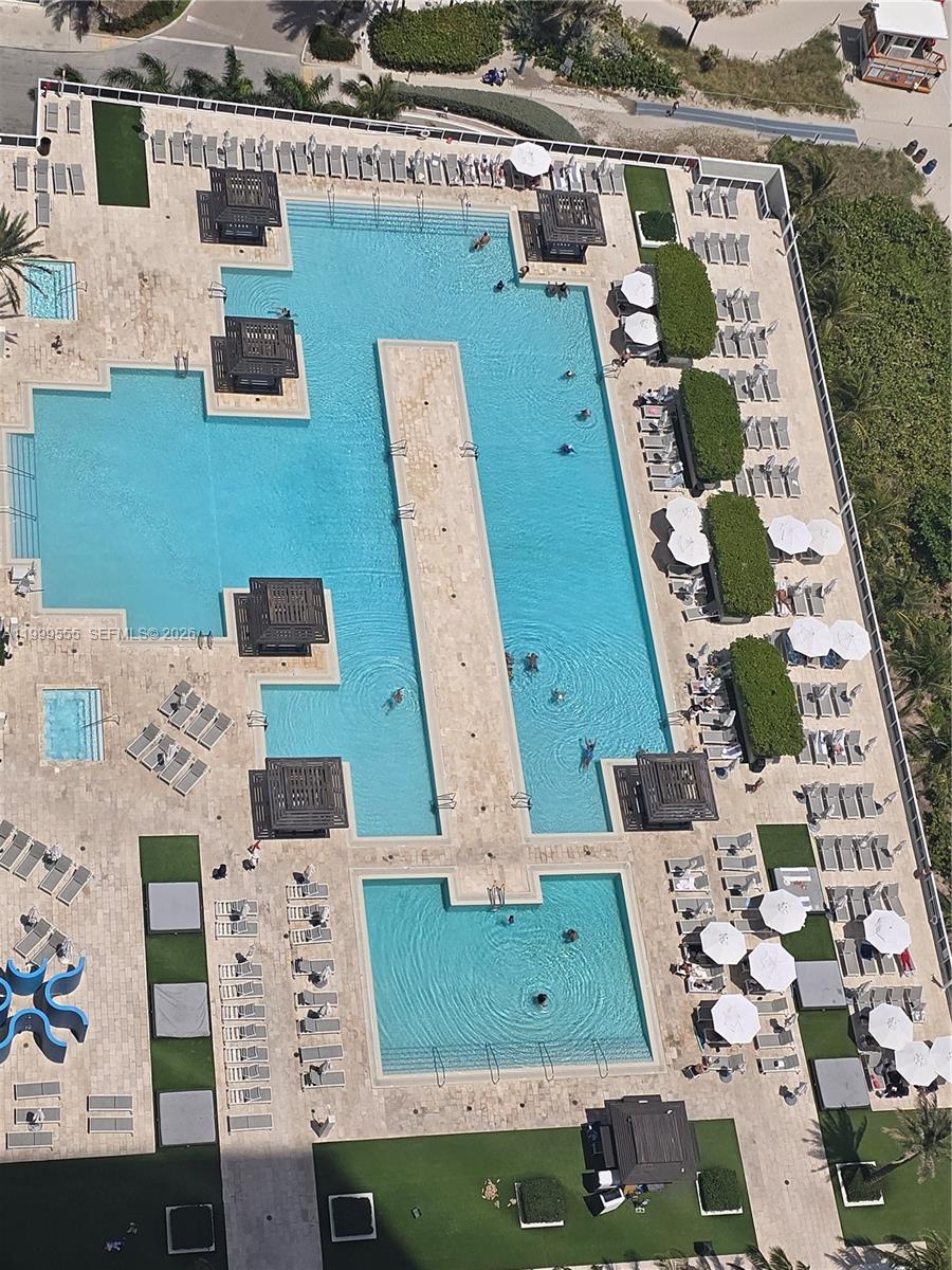 An aerial view shows a large swimming pool complex with multiple sections and lounge chairs — 1830 S Ocean Dr # 4309, Hallandale Beach FL 33009, HALLANDALE BEACH, FL