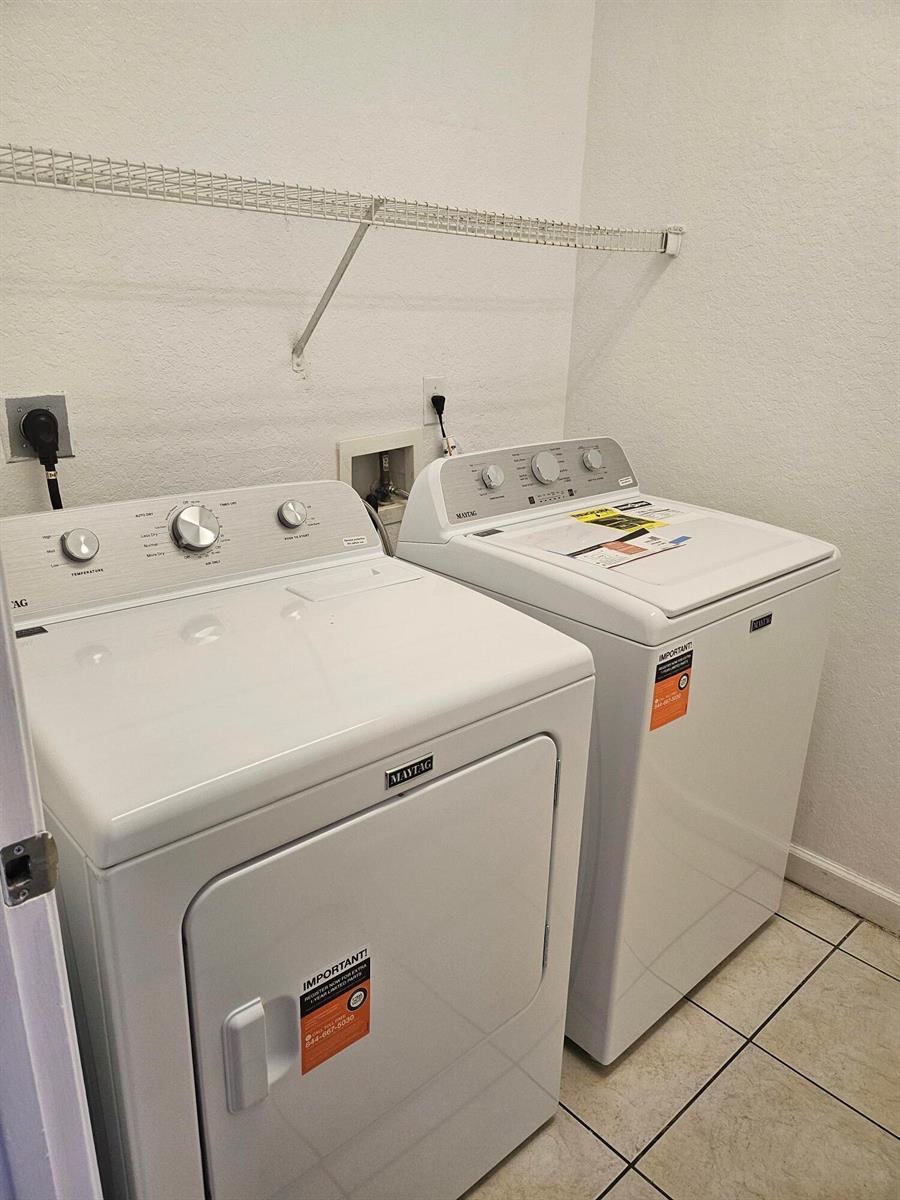 A laundry room features a white Maytag washer and dryer set on a tiled floor — 1193 Colonial Palms Way, Palm Springs FL 33406, PALM SPRINGS, FL