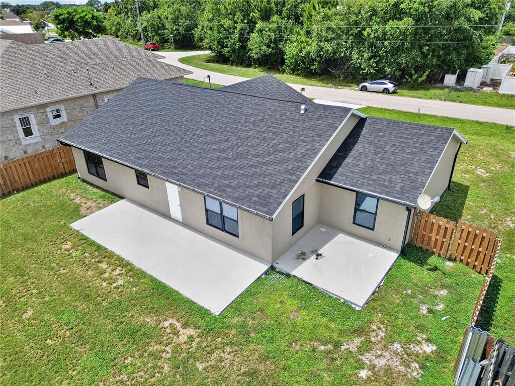 An aerial view shows the back of a house with two concrete patios and a fence — 4209 SW TUSCOL STREET, PORT ST LUCIE, FL