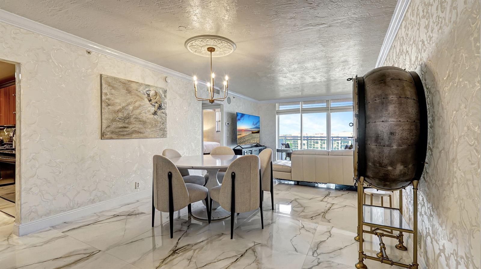A dining area with a marble floor, round table, four chairs, and a chandelier — 3000 S Ocean Drive # 920, Hollywood FL 33019, HOLLYWOOD, FL