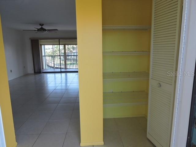 A room with light-colored tile flooring leads to a balcony through a sliding glass door — 1433 MEDITERRANEAN DRIVE UNIT C, PUNTA GORDA, FL