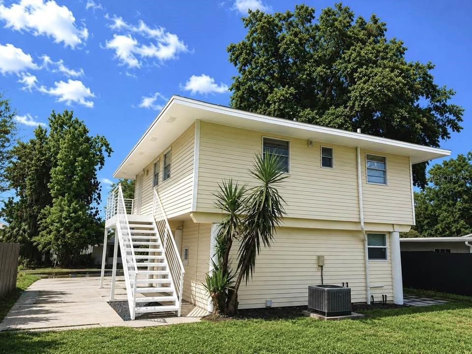 A two-story house with yellow siding and an exterior staircase leading to the upper level — 2568 LOTAFUN AVENUE, WINTER PARK, FL