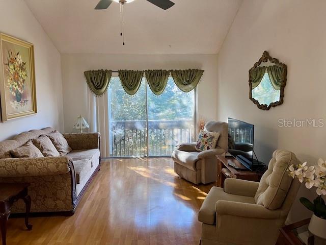 A living room features a sofa, two armchairs, a television, and a sliding glass door — 370 WINDMEADOWS STREET UNIT 370, ALTAMONTE SPRINGS, FL